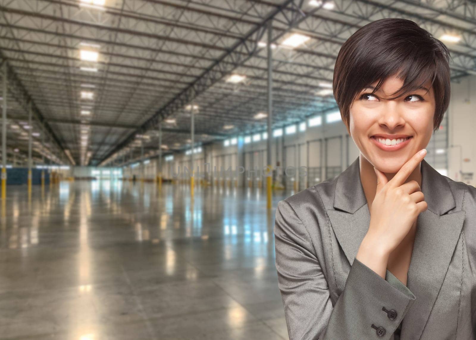 Thinking Mixed Race Businesswoman Standing in Empty Industrial Warehouse.