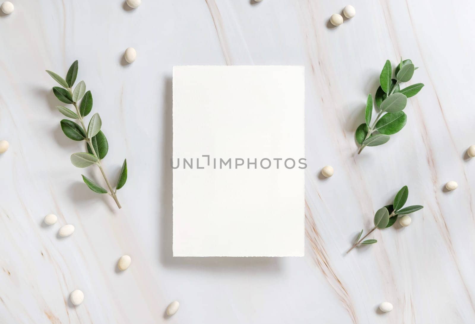 Vertical card on a marble table decorated with eucalyptus branches and white stones top view, Wedding Mockup. Romantic flat lay with blank menu card. Minimal composition. Close to nature