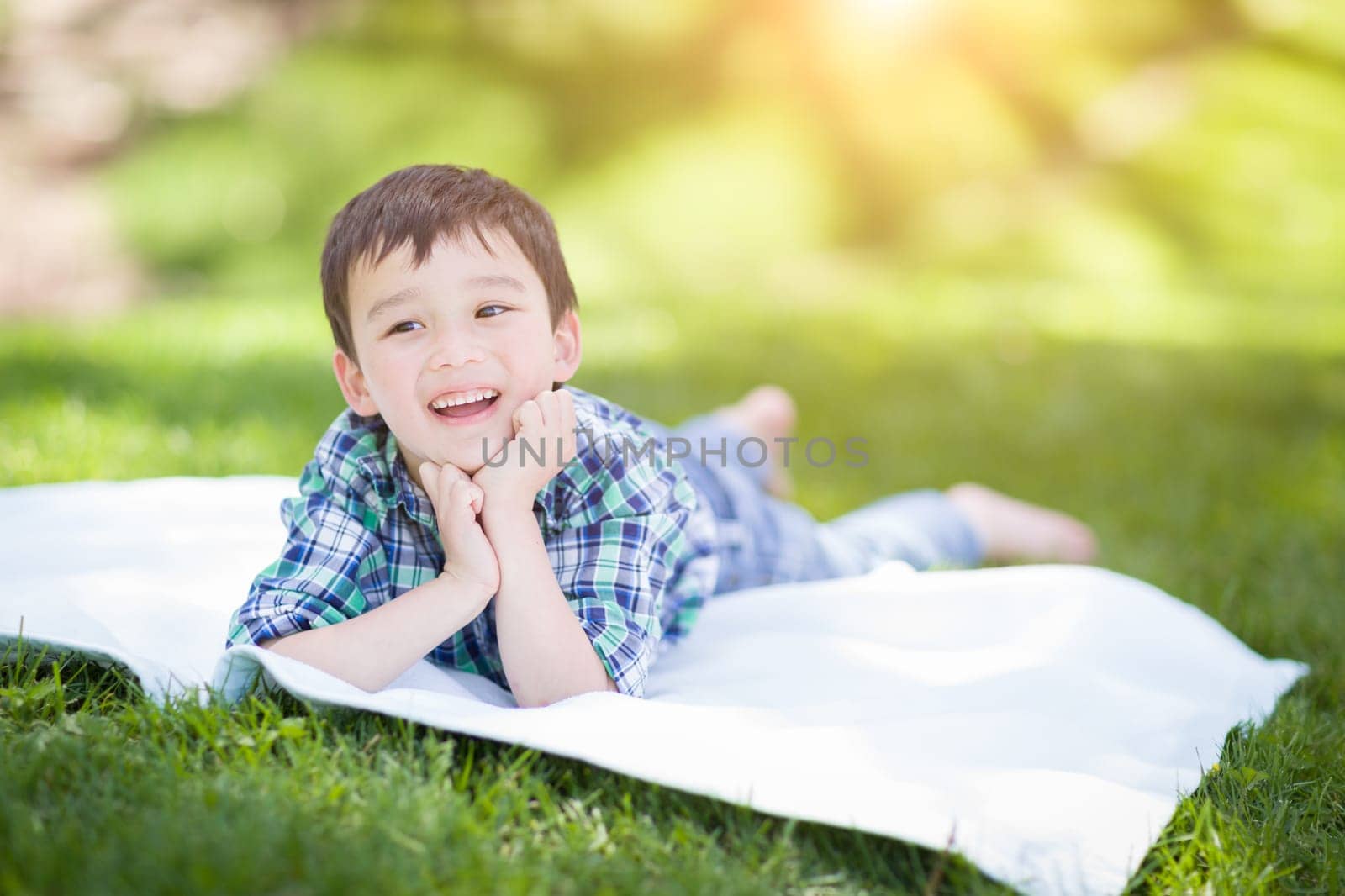 Mixed Race Chinese and Caucasian Young Boy Relaxing Outside On The Grass