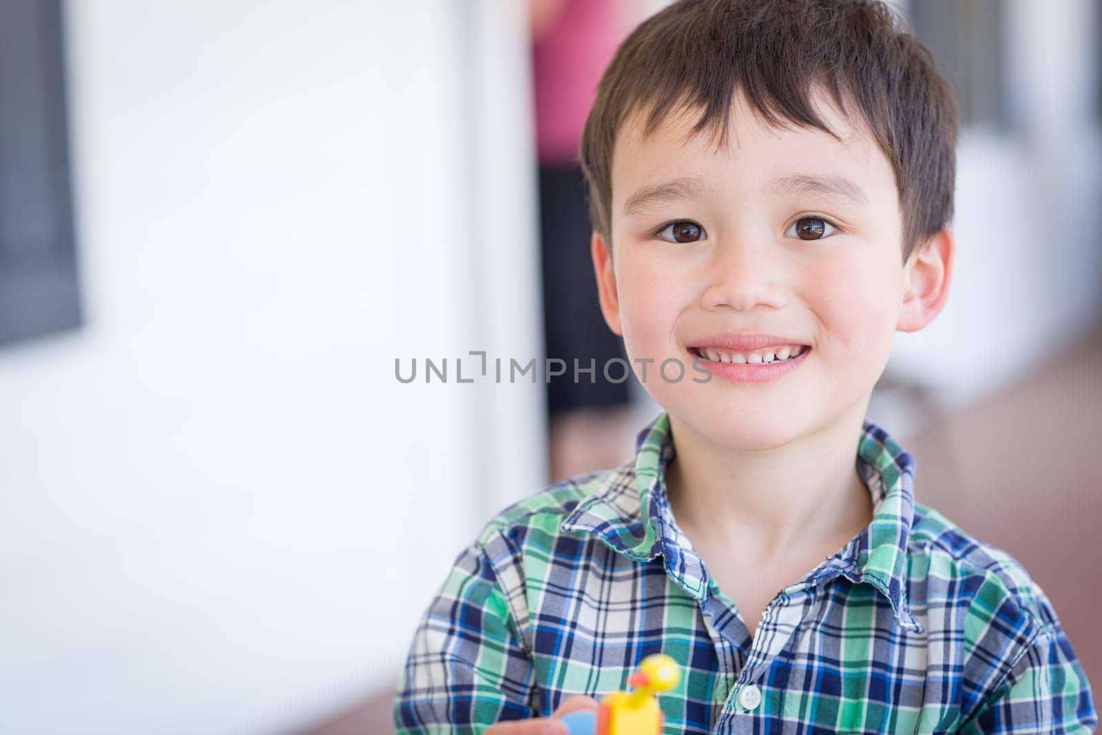 Portrait of Mixed Race Chinese and Caucasian Young Boy With Toy