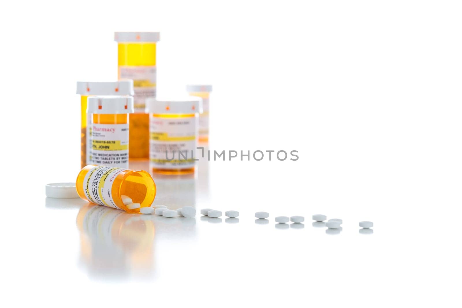 Non-Proprietary Medicine Prescription Bottles and Spilled Pills Isolated on a White Background.