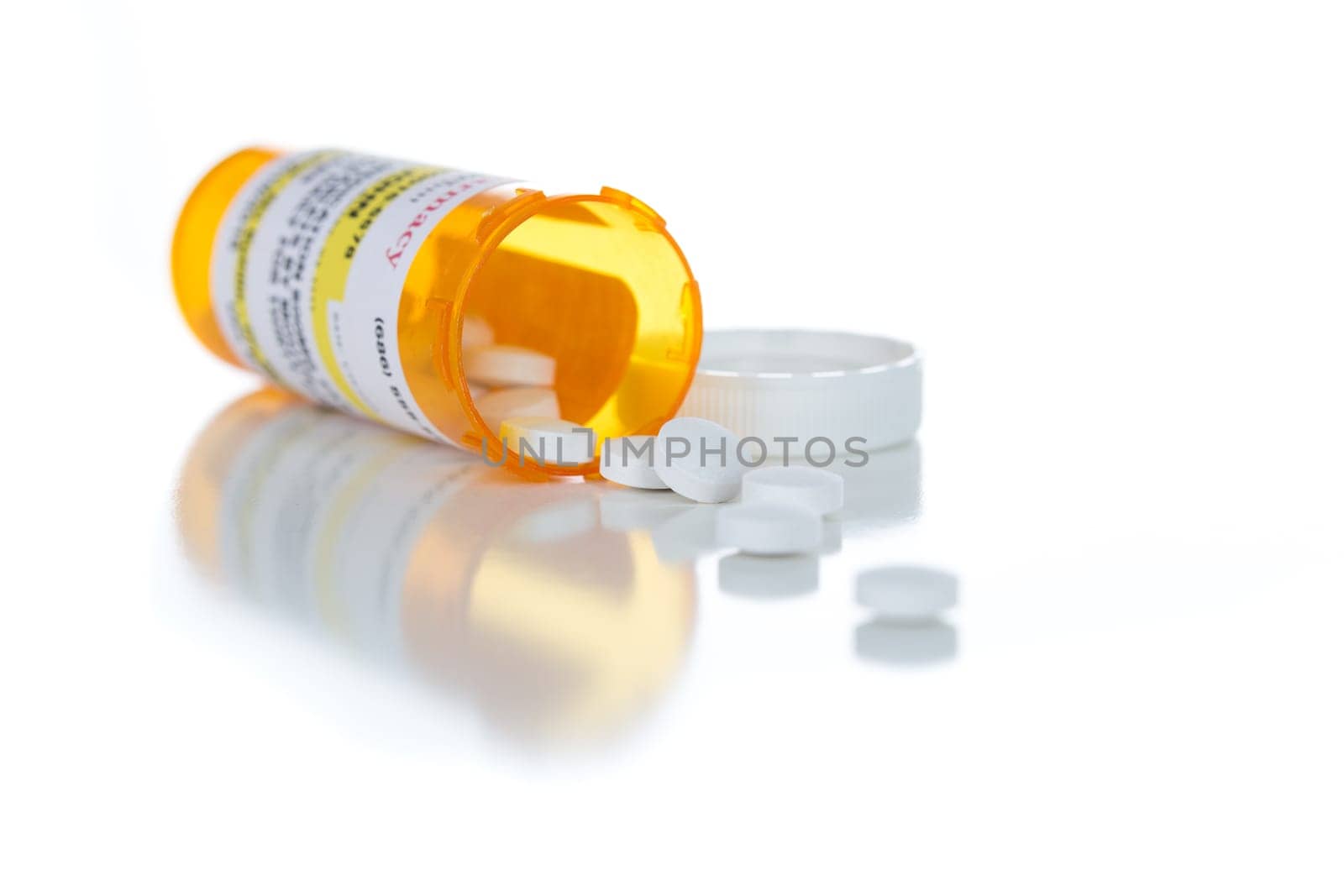 Non-Proprietary Medicine Prescription Bottle and Spilled Pills Isolated on a White Background.
