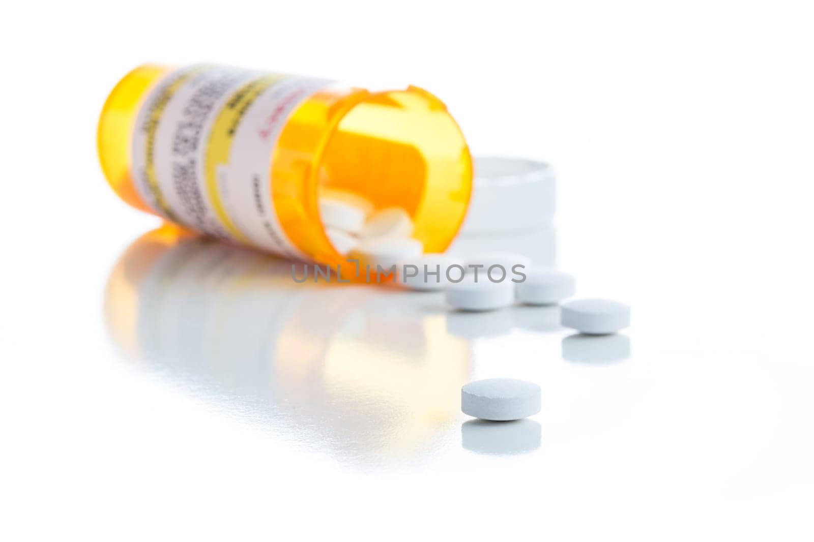 Non-Proprietary Medicine Prescription Bottle and Spilled Pills Isolated on a White Background.