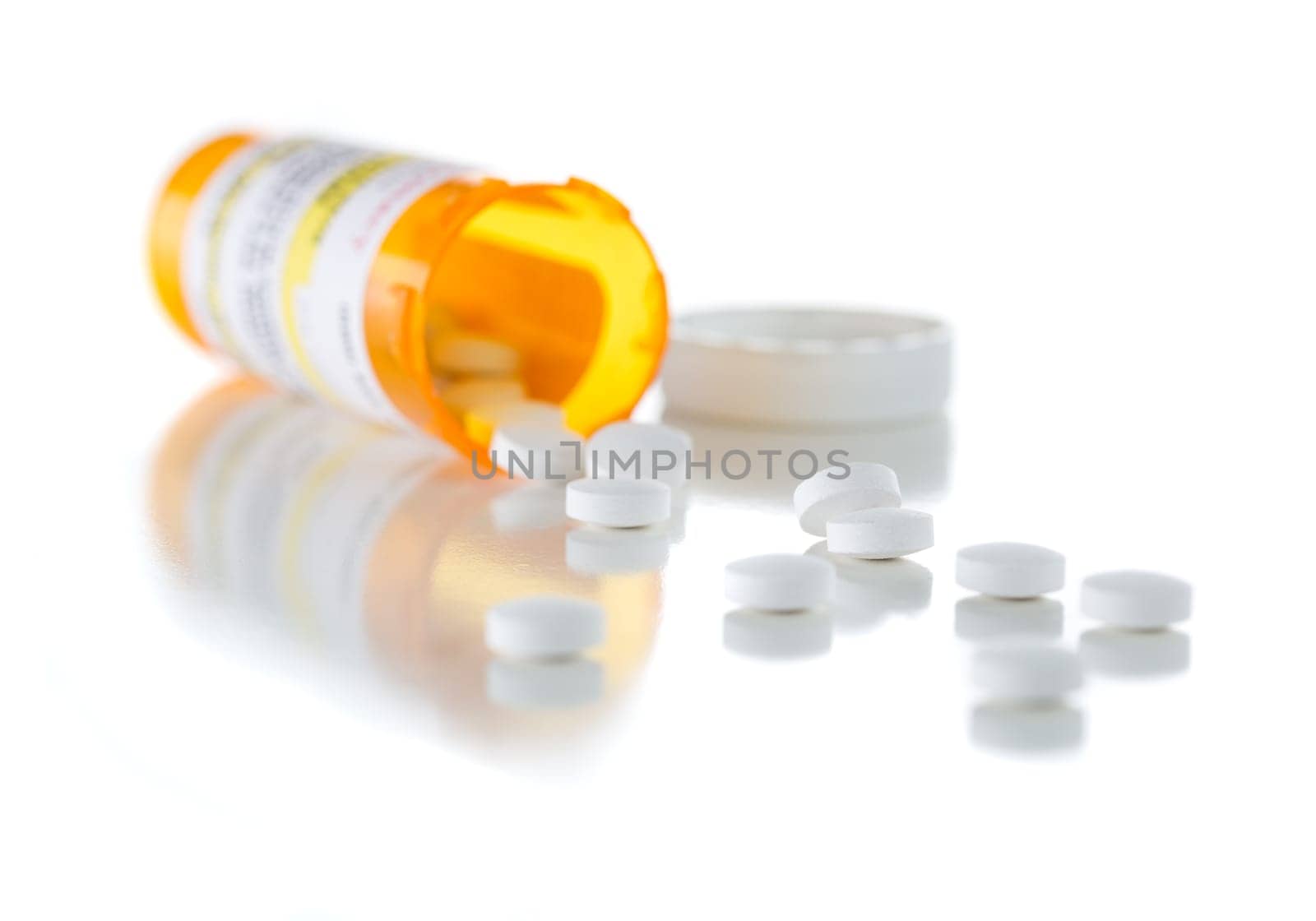 Non-Proprietary Medicine Prescription Bottle and Spilled Pills Isolated on a White Background.