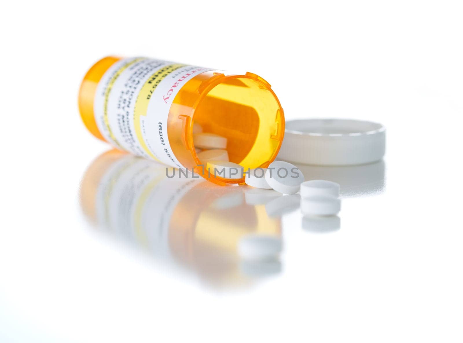 Non-Proprietary Medicine Prescription Bottle and Spilled Pills Isolated on a White Background.