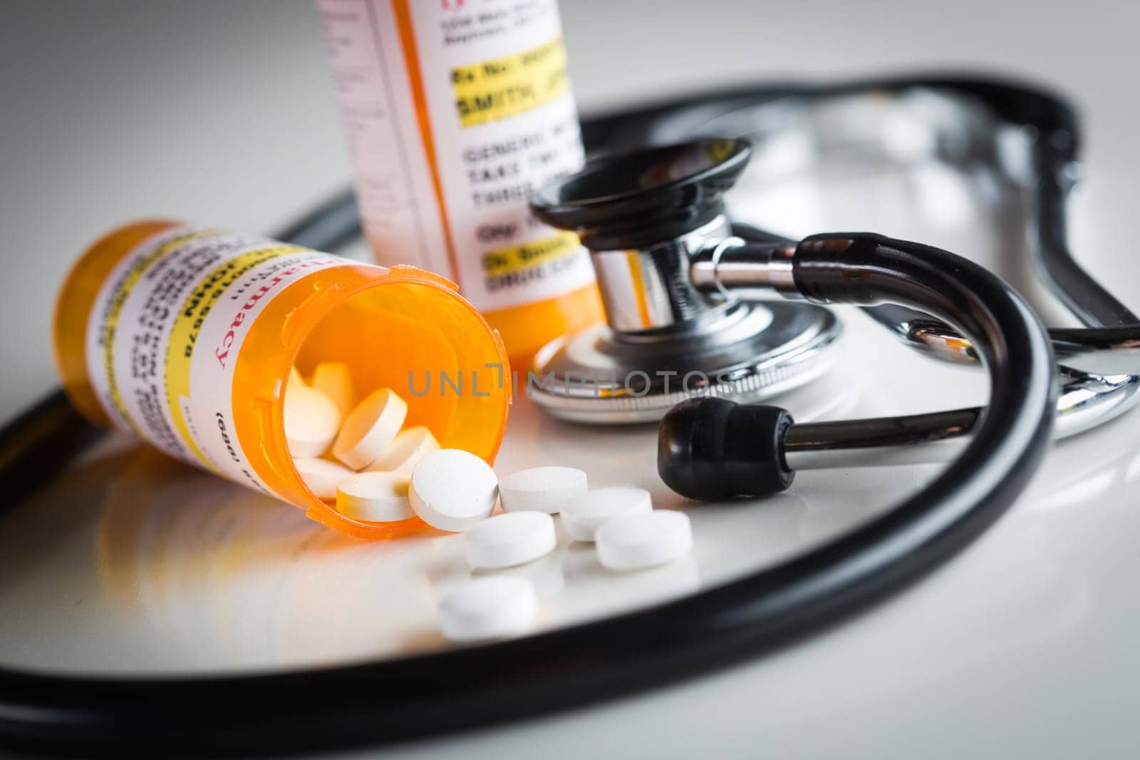Non-Proprietary Medicine Prescription Bottles and Spilled Pills Abstract with Stethoscope.