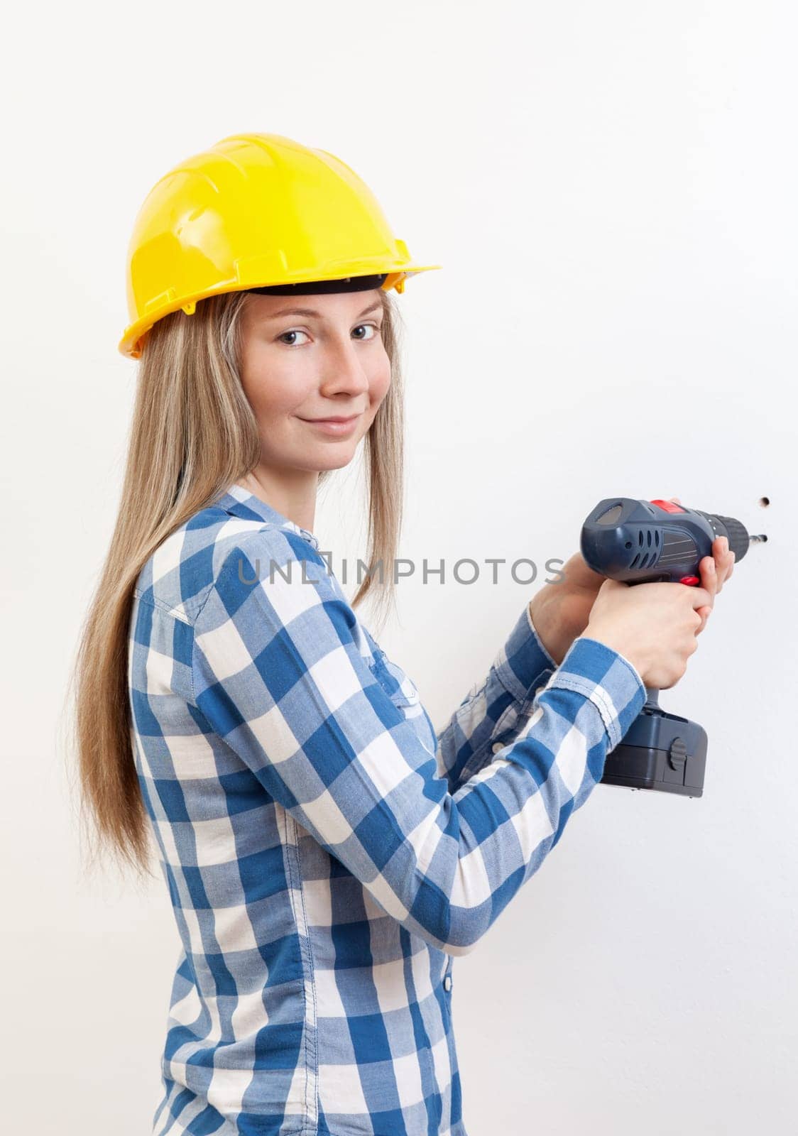 Young woman doing the DIY work and wearing protective helmet