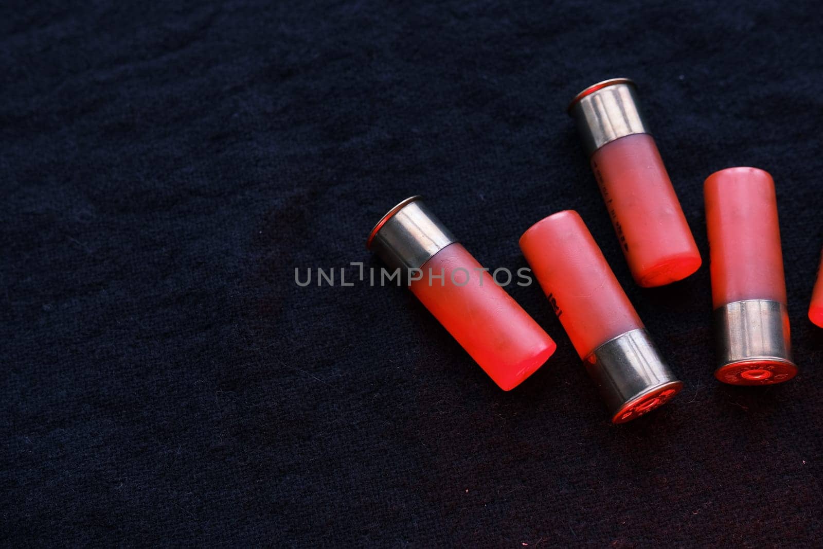 Shotgun shells on a black surface. Ammunition for 12 gauge smoothbore weapons. Hunting ammunition. Dark background