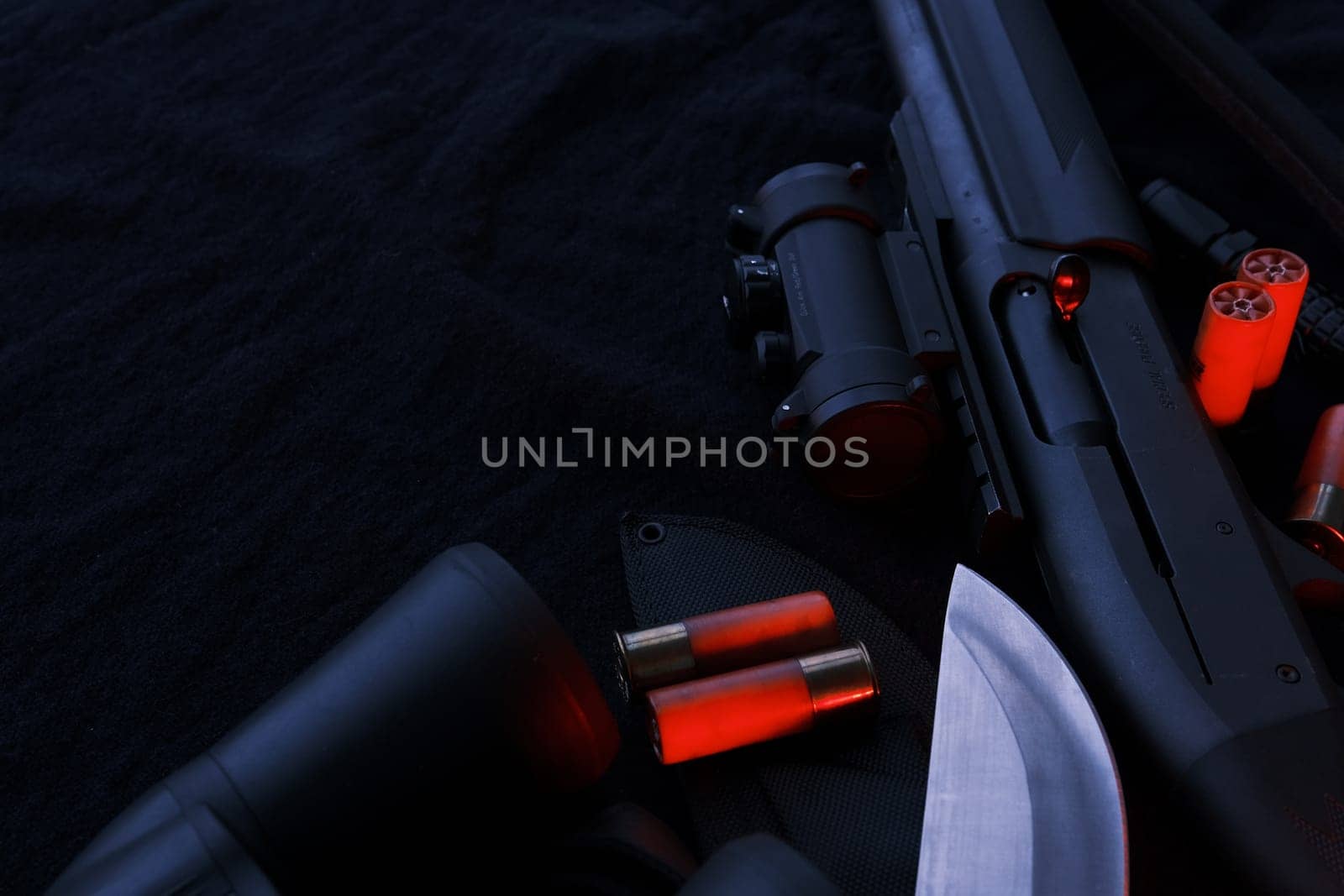 Weapon on black cloth: binoculars, flashlight, knife, rifle, shells,top view. Top view of knife rifle shells