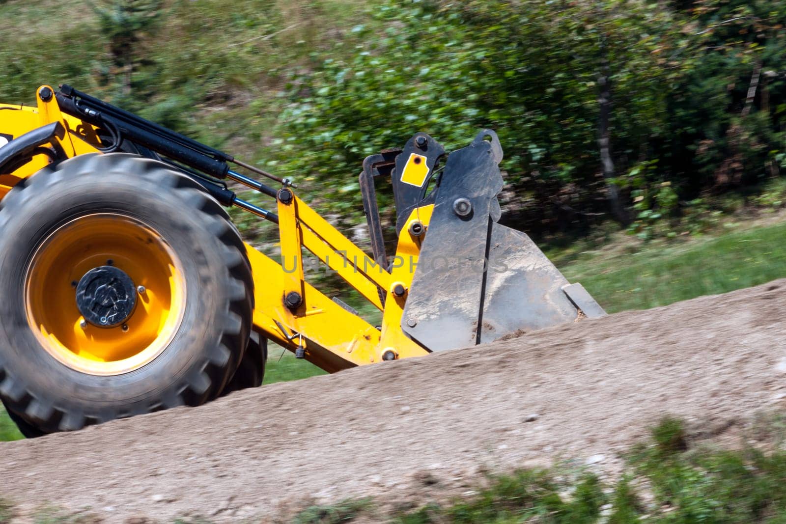 detail yellow excavator traveling on the road, panning image