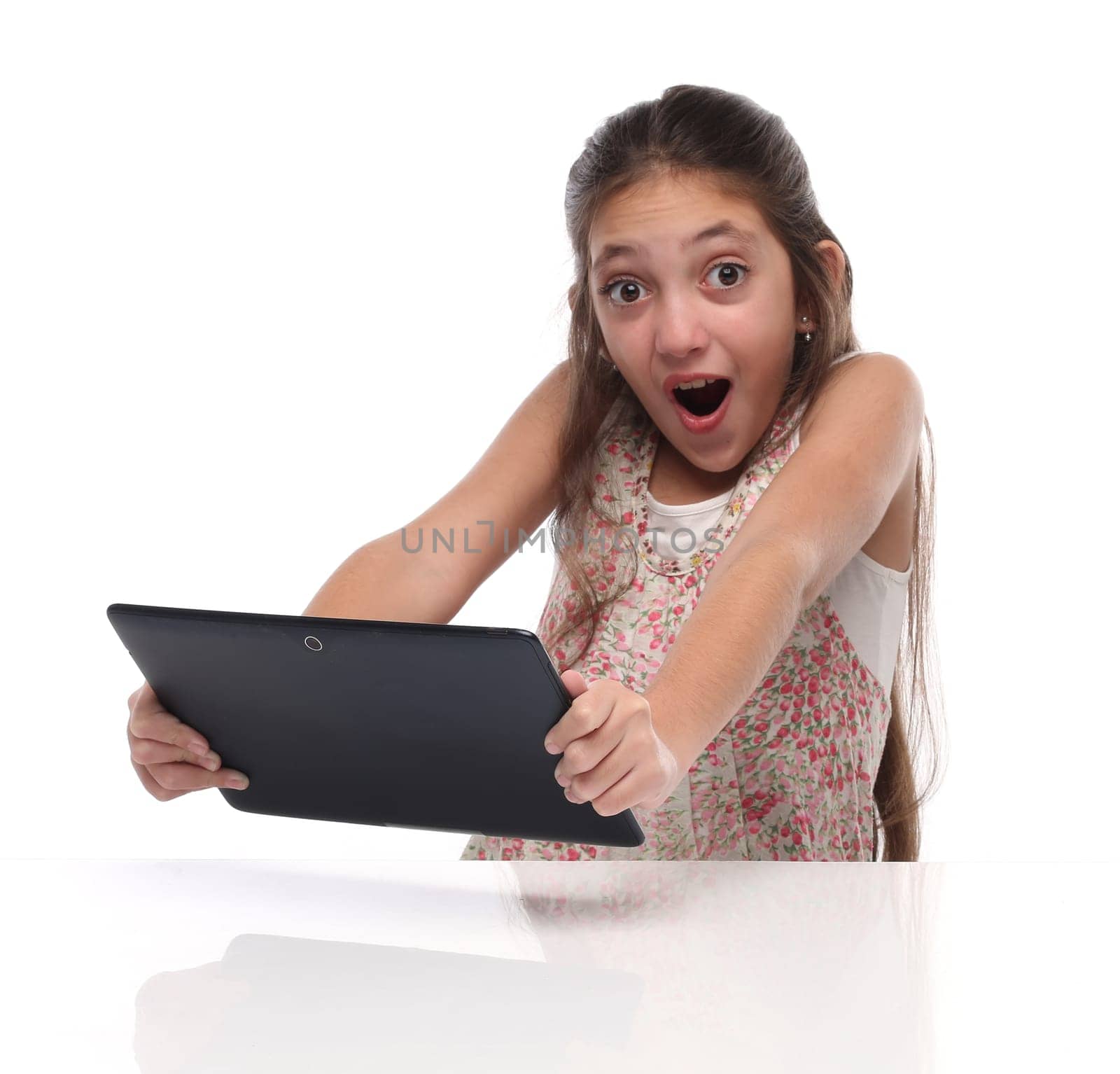 Surprised pre-teen girl with a tablet computer. Isolated on white
