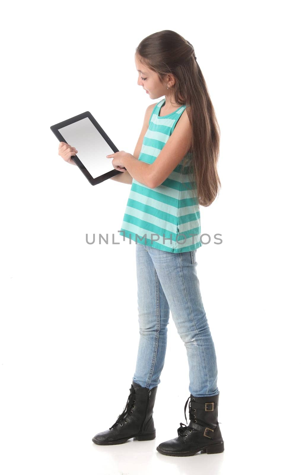 Beautiful pre-teen girl using a tablet computer. Clipping path for the screen