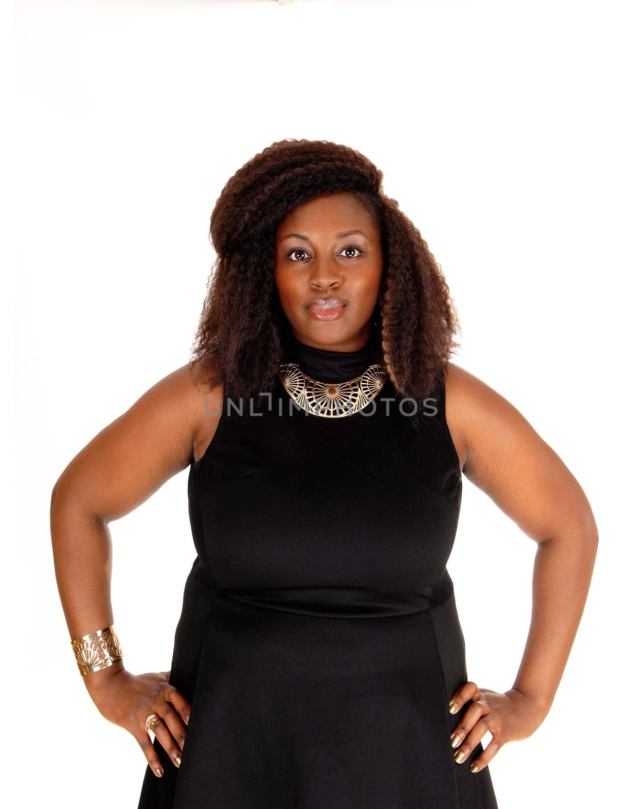A portrait picture of a African American woman in a black dress with her.hands on her hips, isolated for white background..