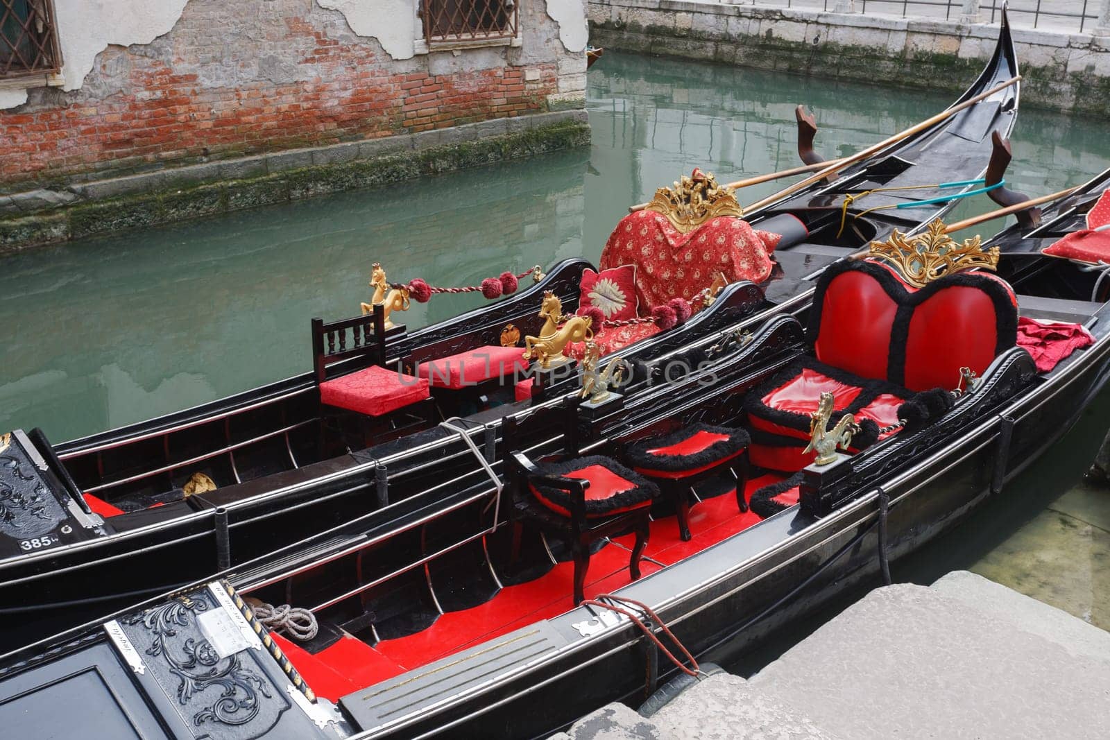A couple of gondoles along a venetian canal