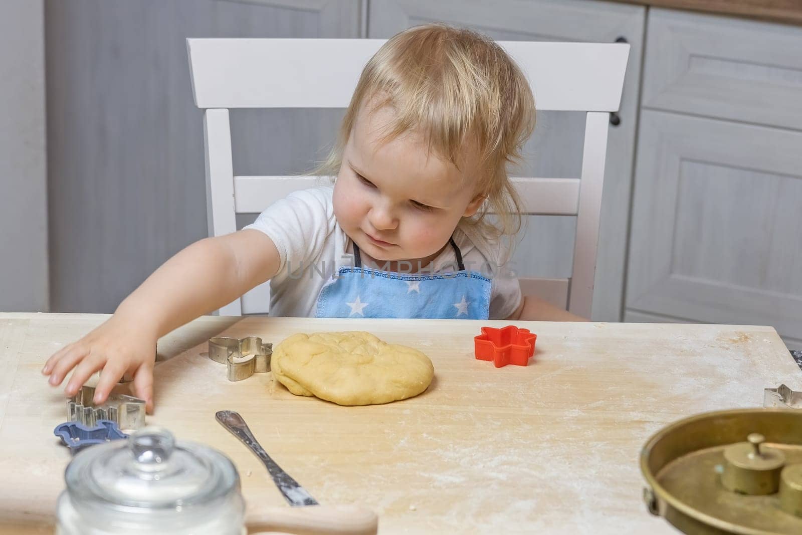 Little boy helps to bake Christmas cookies. Little helper. Horizontally.