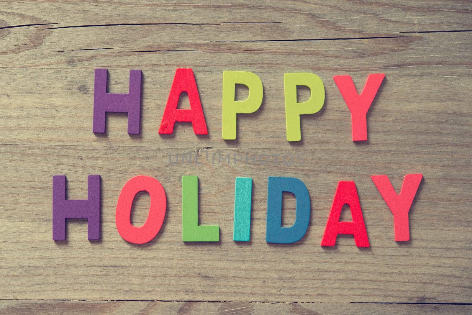 The words "HAPPY HOLIDAYS"" on wooden plank."