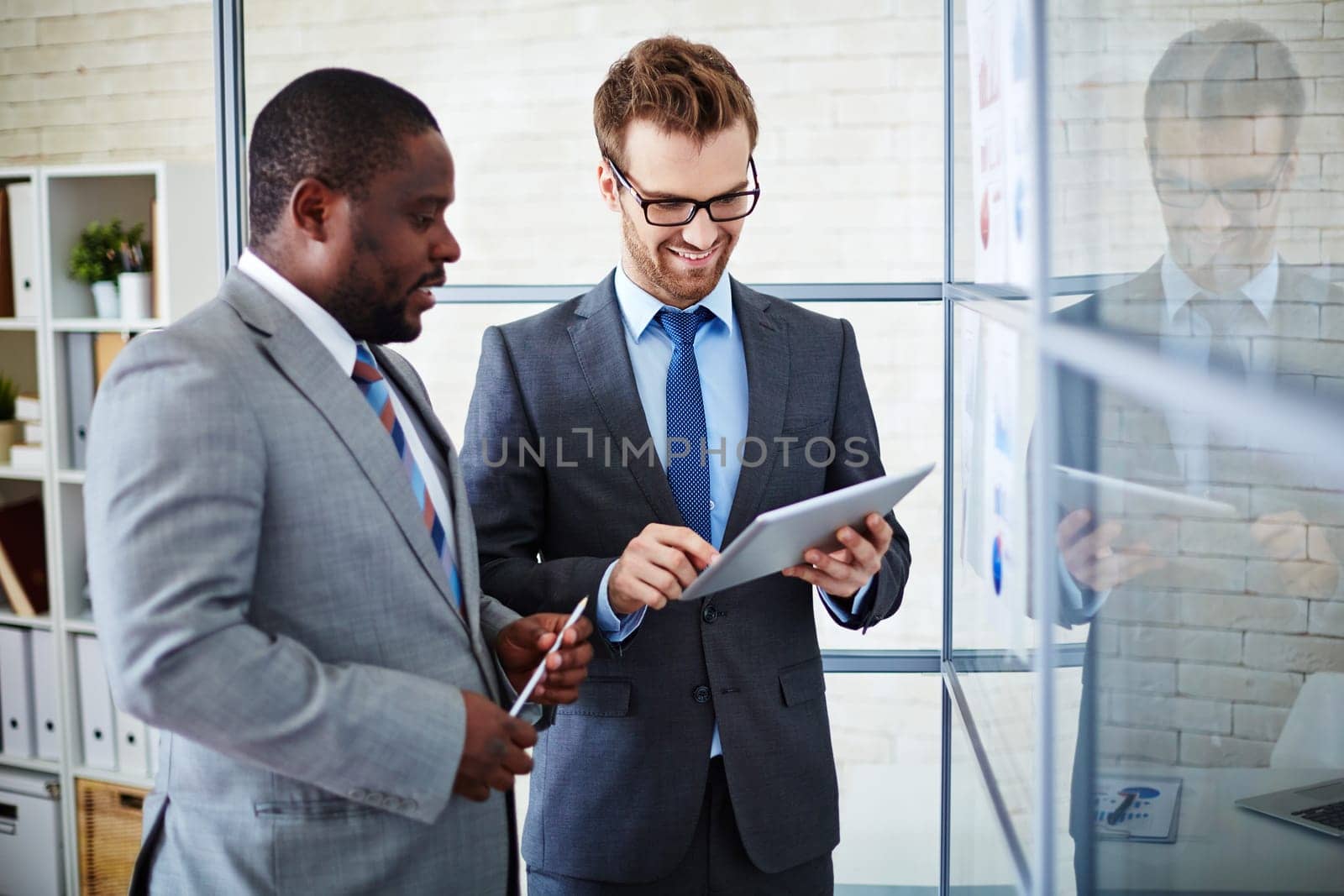 Two businessmen browsing in the net at meeting in office