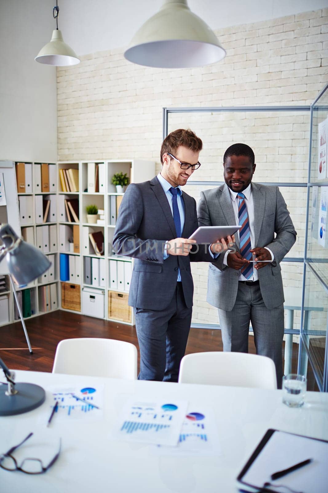Confident managers looking at data while discussing new ideas