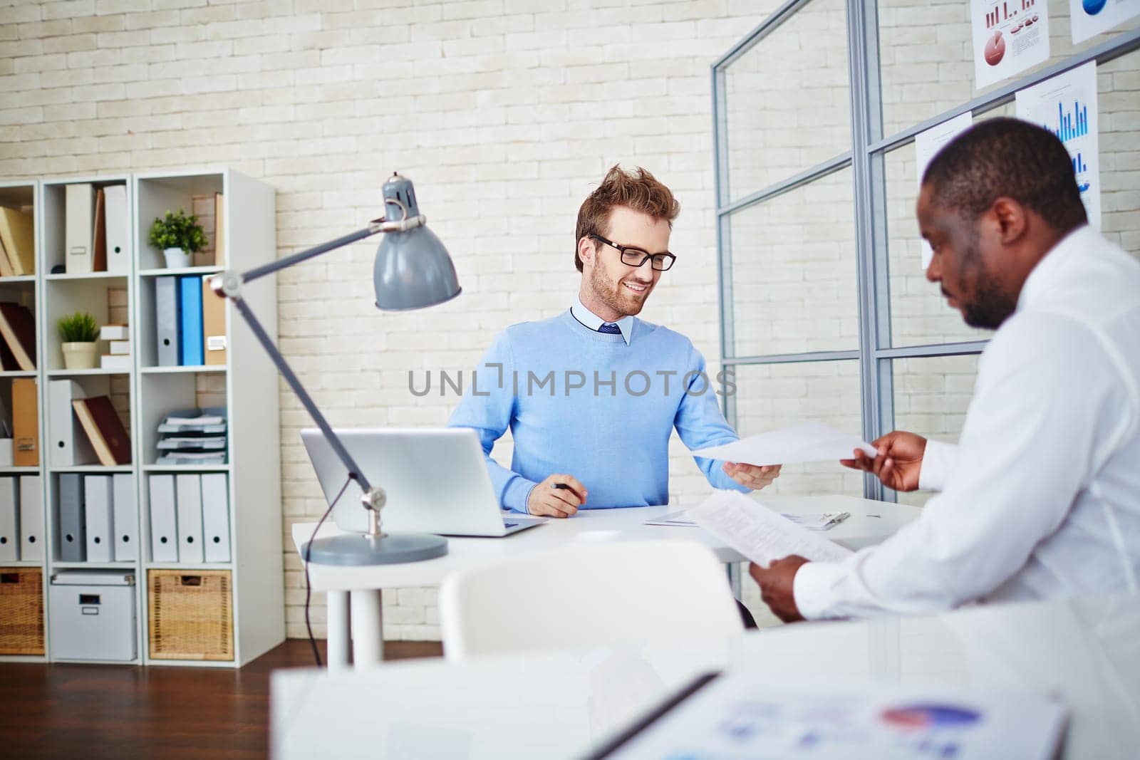 Young man passing over his resume to employer while hiring for job
