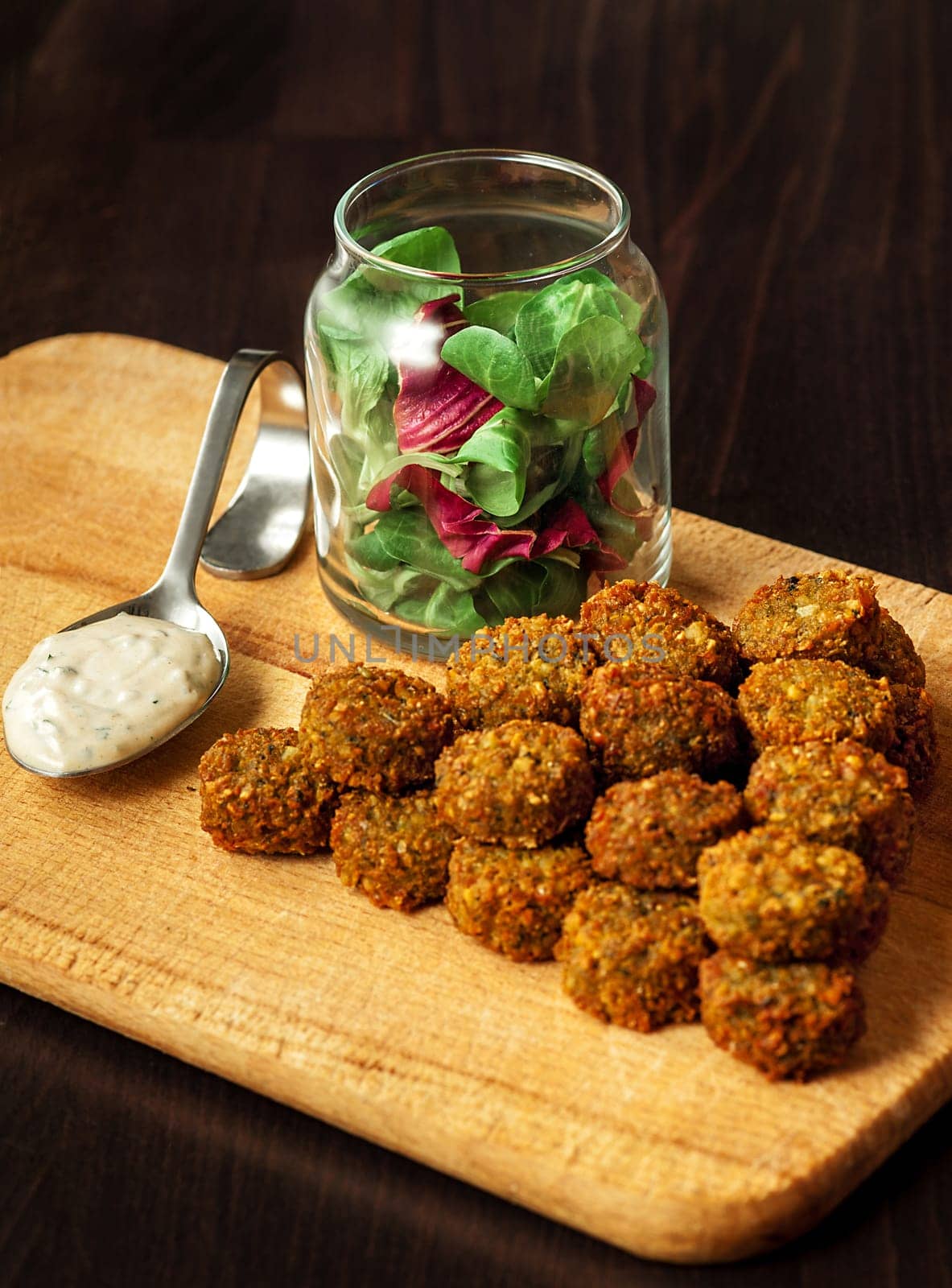 fresh vegetarian falafel  with sauce and fresh herbs on wooden blackboard
