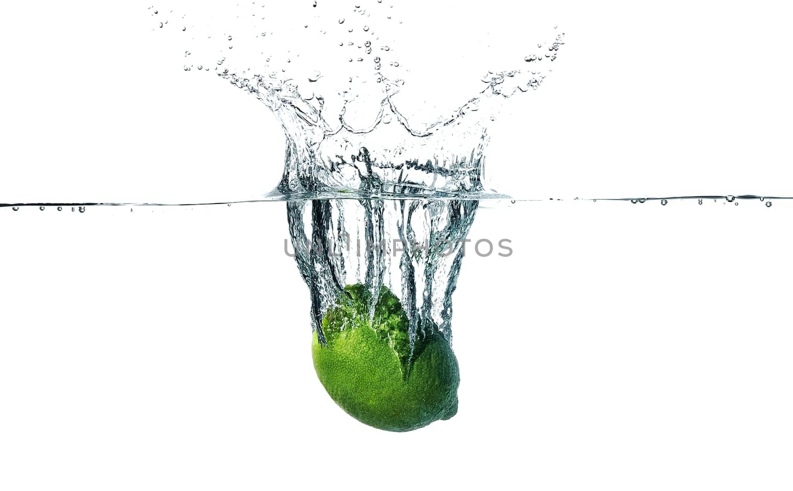 Fresh lime falling into water, isolated on white background