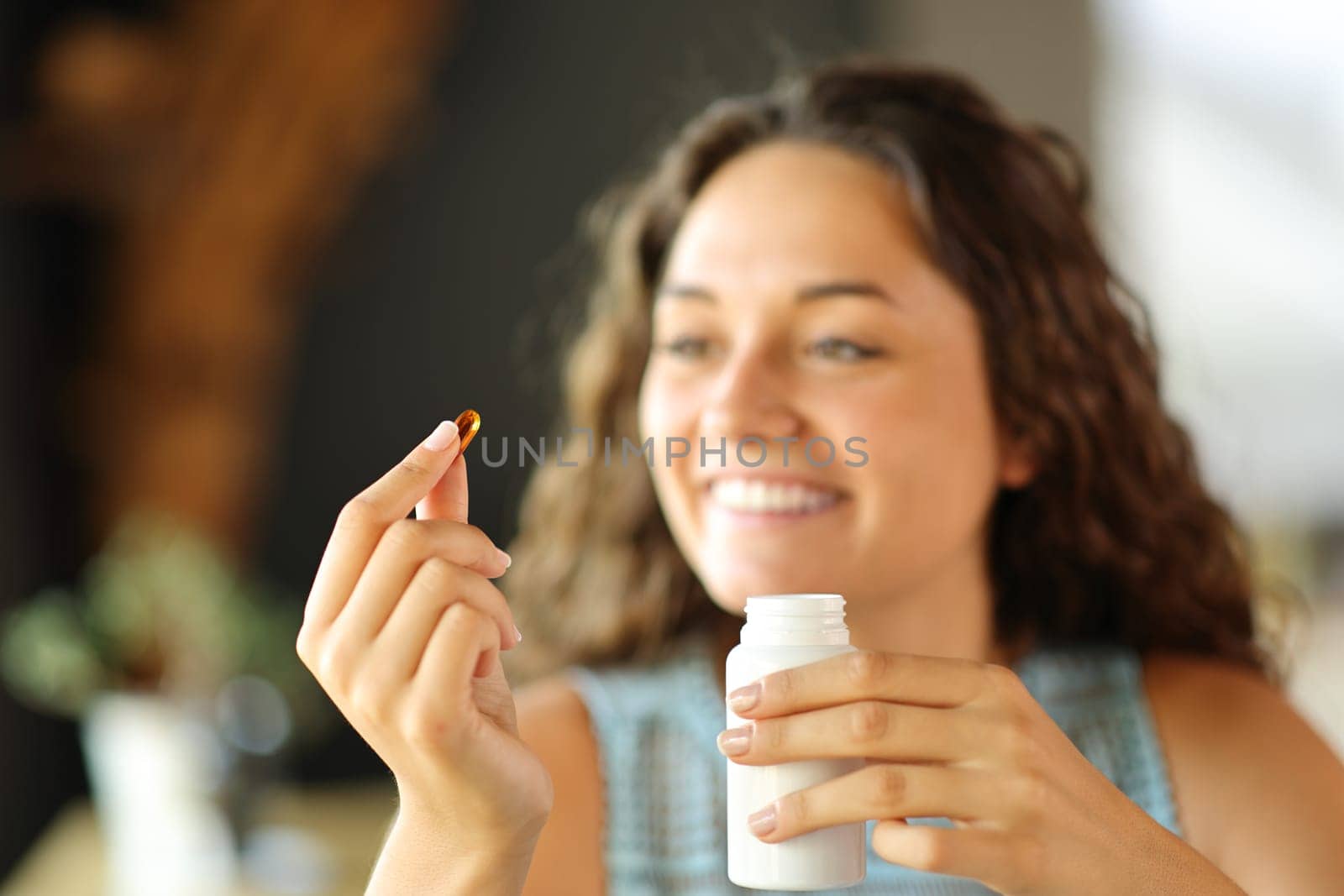 Happy woman ready to eat a vitamin pill at home or restaurant