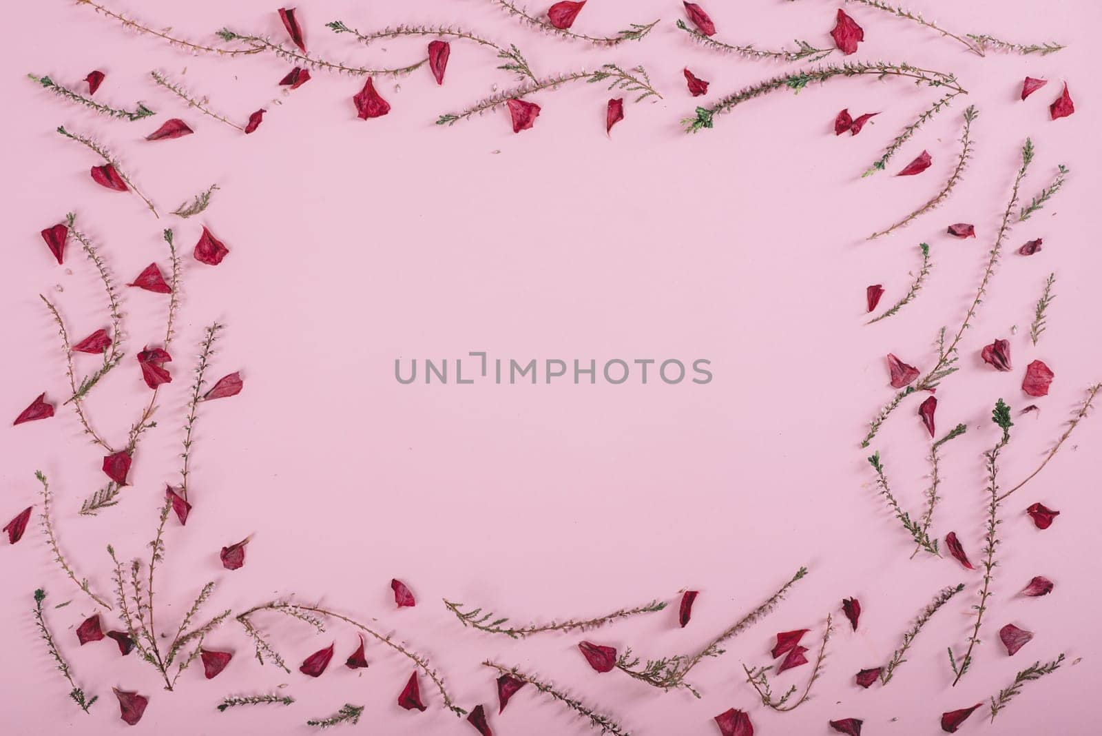 Floral pattern frame with flowers and petals over pink background. Flat lay border. Valentine's day design from above.
