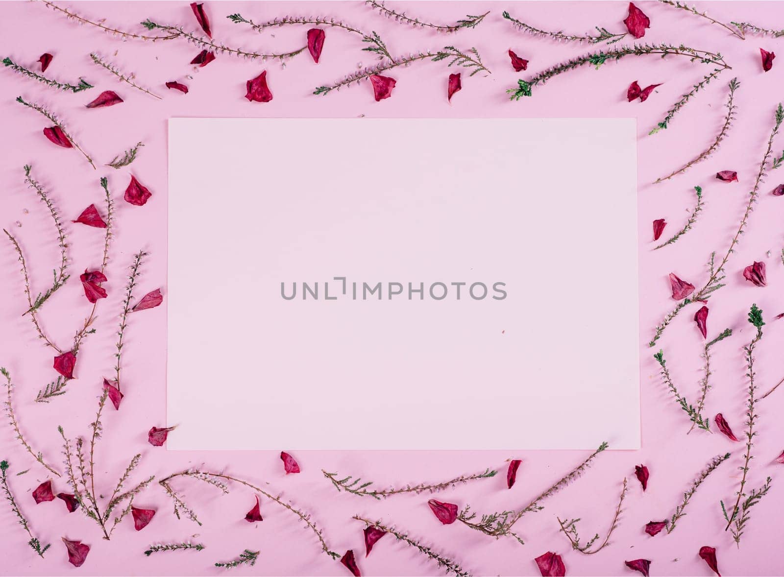 Floral pattern and empty valentine card with flowers and petals over pink background top view. Flat lay frame. Valentine's day design greeting card from above.