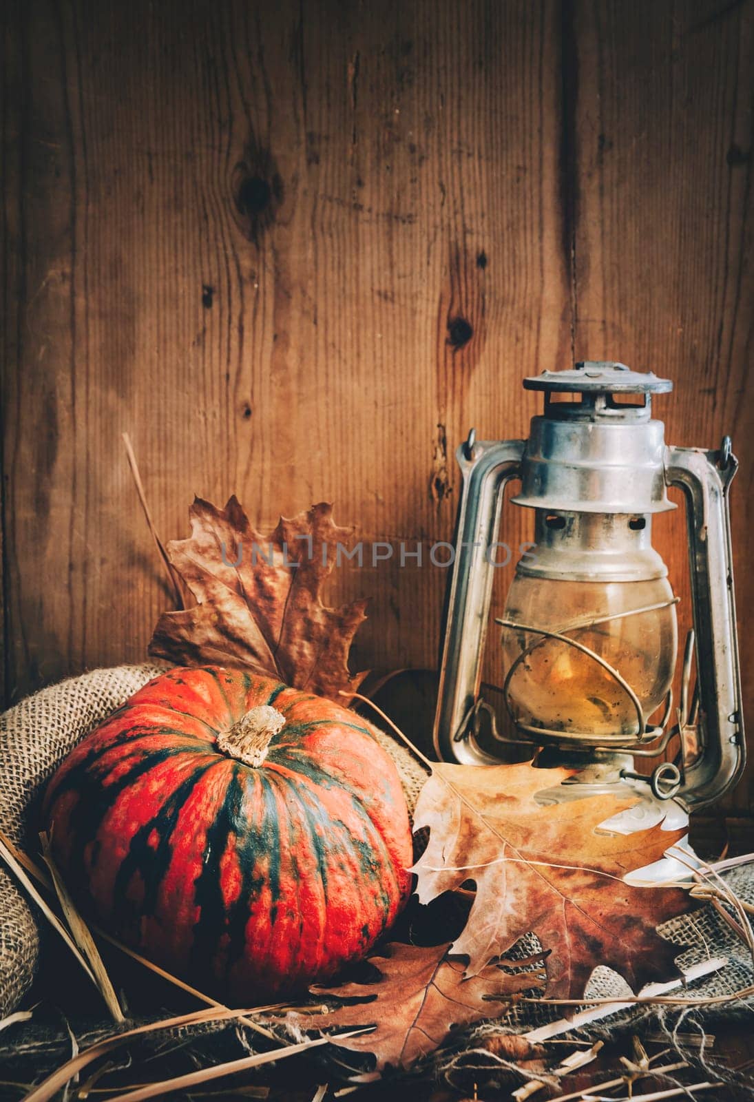Still life with halloween pumpkin and vintage lantern on rustic wooden background. Happy halloween and thanksgiving invitation card.