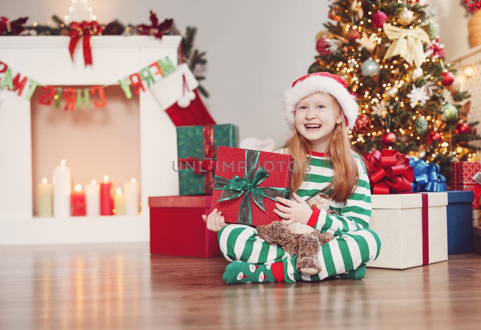 Little girl sitting in the Christmas decorating room. Concept of the christmastime and New Year eve.