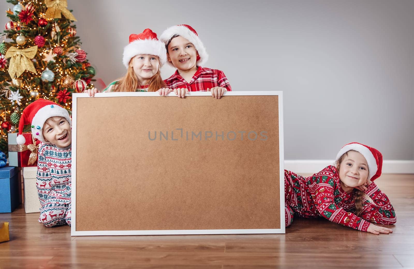 Four children indoors with empty banner on Christmas holiday. Concept of postcard, banner and info.