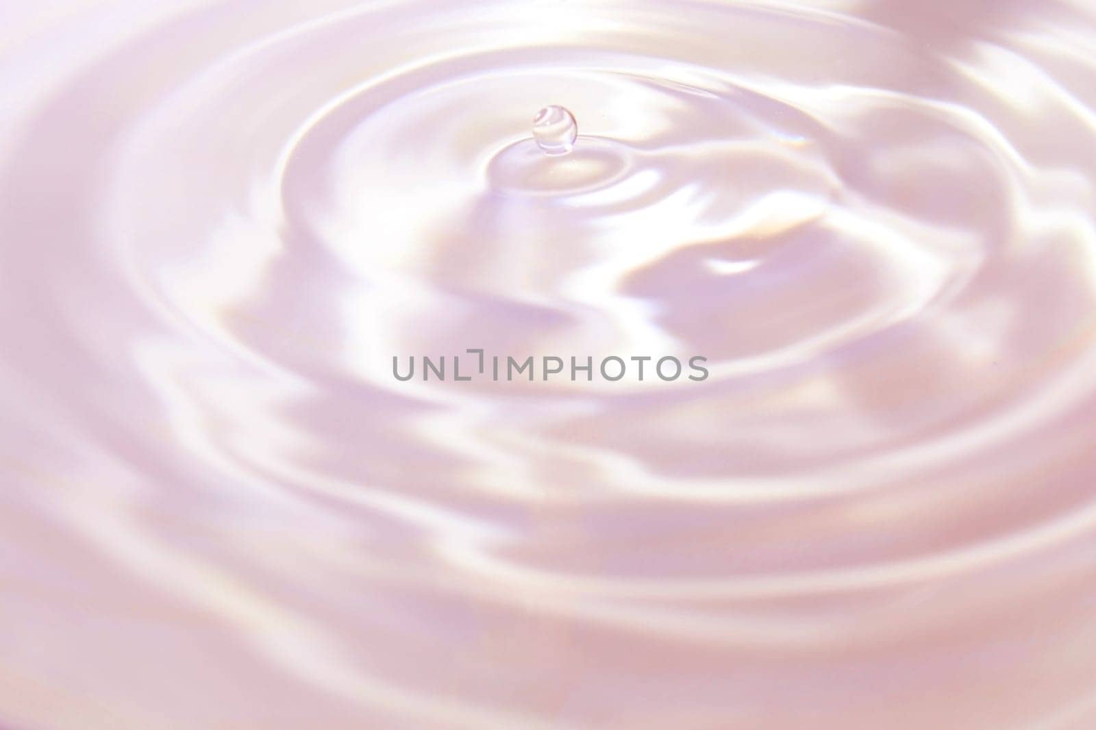Beautiful pink-violet background in the form of circles on the water and a small drop of water. Universal abstract background.