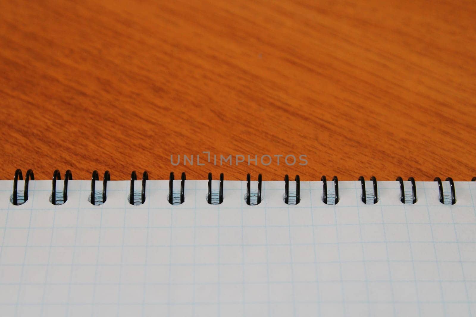 Notepad on a wooden table with copy space. View from above. Design blank.