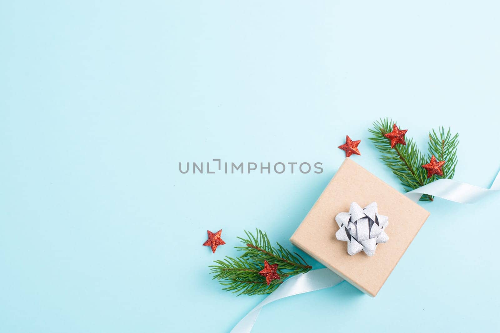 Christmas holiday greeting card with little gift boxes, stars and fir branches, blue background
