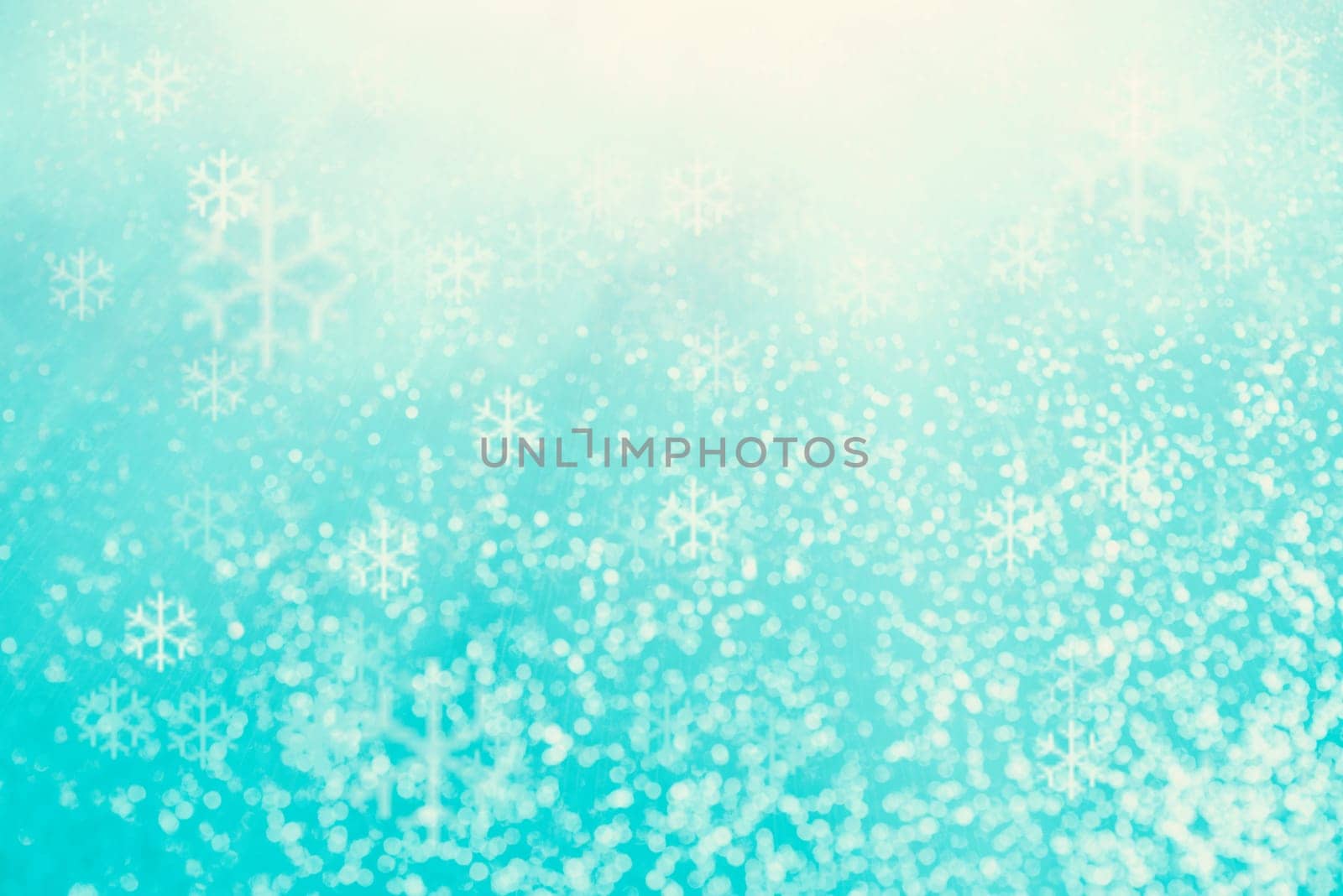 Blue bokeh background with snowflakes for christmas, defocused round lights and sunbeams, flare overlay