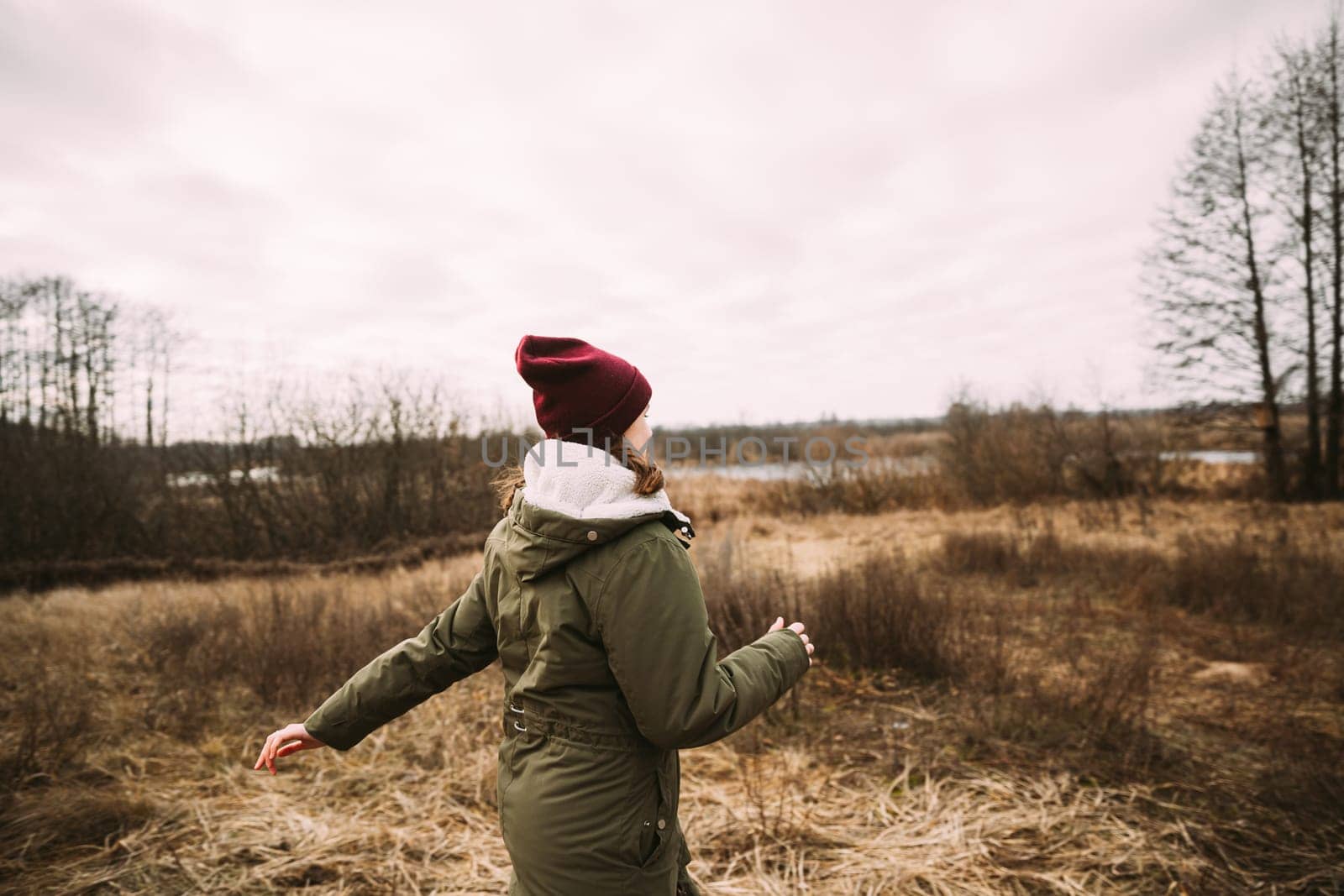 Single Young Pretty Caucasian Happy Girl Woman In Green Jacket Running In Autumn Forest. Enjoy Outdoor Fall Nature.