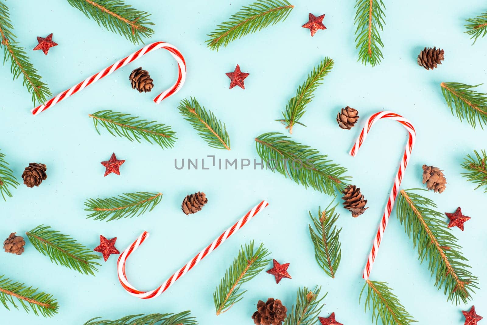 Christmas holiday background with candy cane, fir branches, pine cones and red stars, winter season