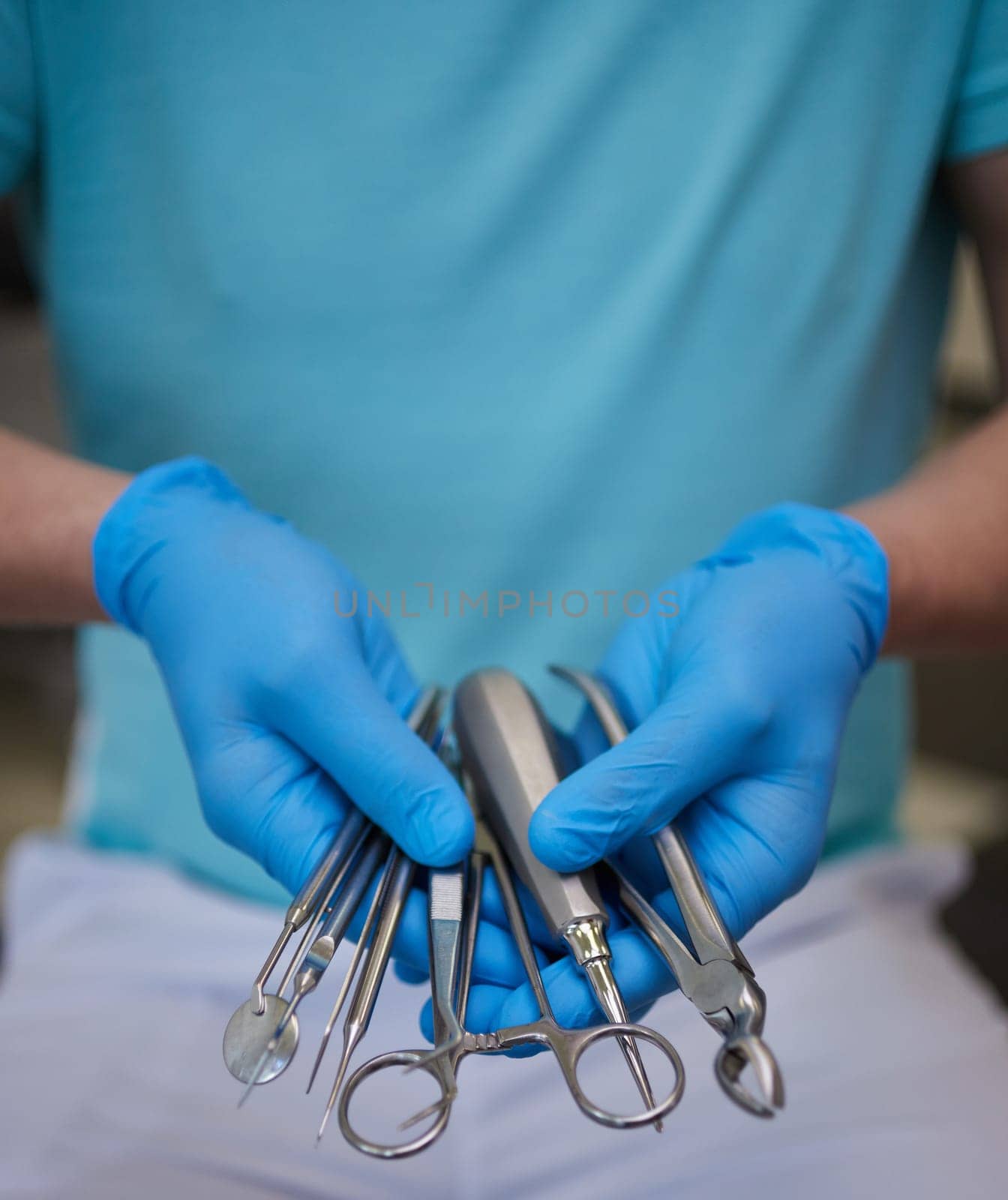 Close up of hands dentist in sterile latex gloves holding dental tools. Professional dentist uses special sterilized medical instruments in modern dental clinic. Concept of medical instruments.