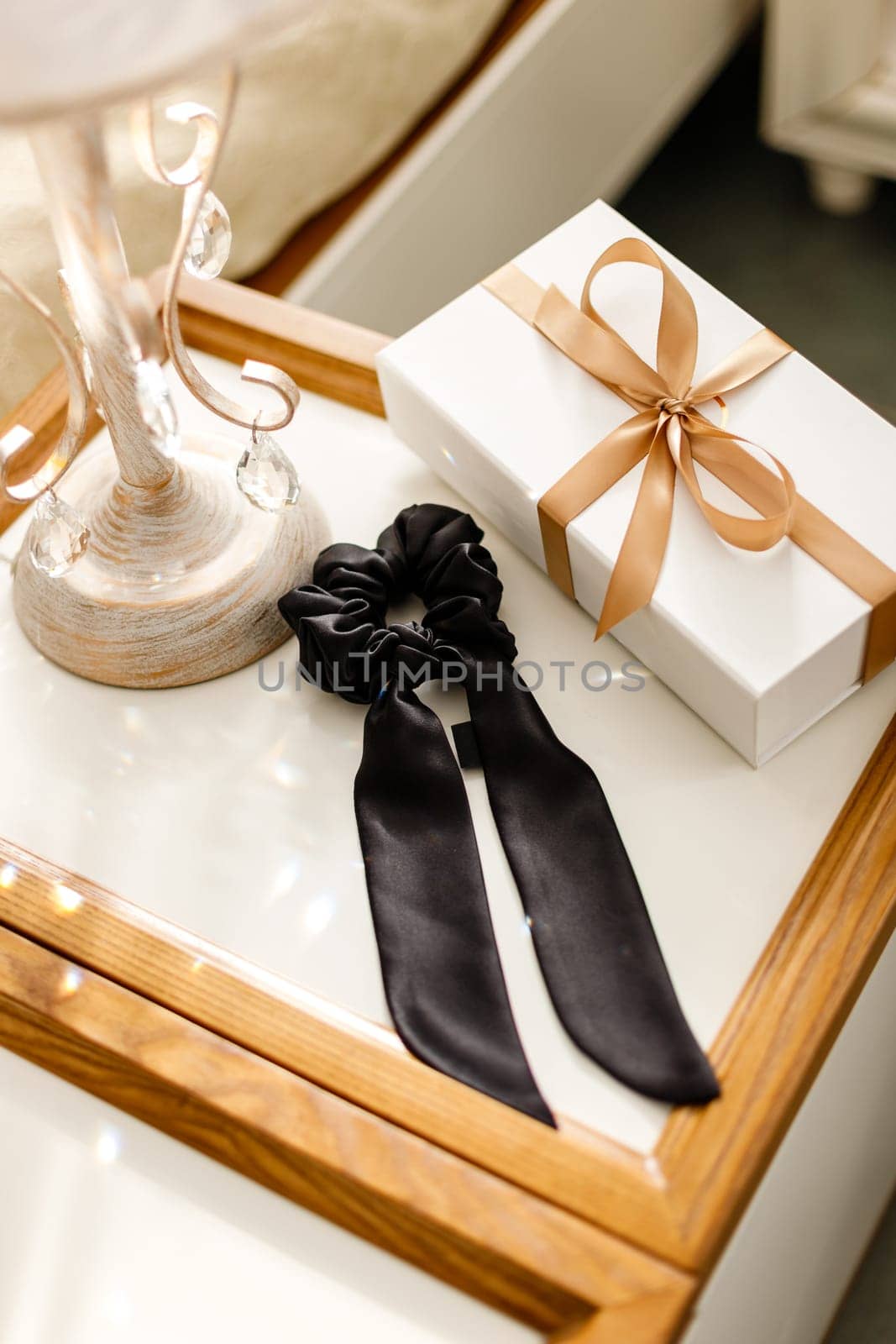 Hair ties made of silk fabric for real elegant ladies. Exquisite women's handmade scrunchy lie on table among luxury interior details. Hair accessories concept.
