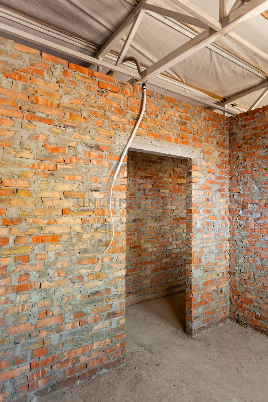 Brickwork. Completed brick wall and door frame of construction site in new residential building. Bare walls ready for plastering. Construction site of private house.