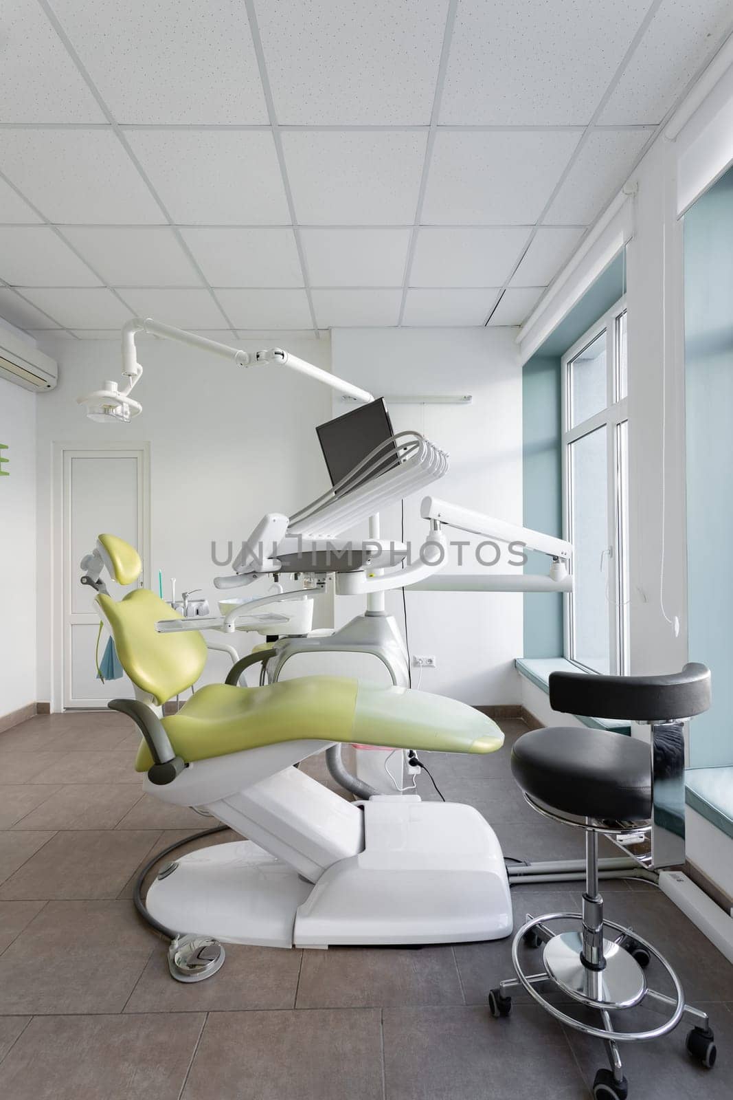 Dentistry. Empty spacious dental office with dental chair and variety of equipment. Interior of dental office with modern dental units, chairs, equipment, tools and lamp used by dentists.