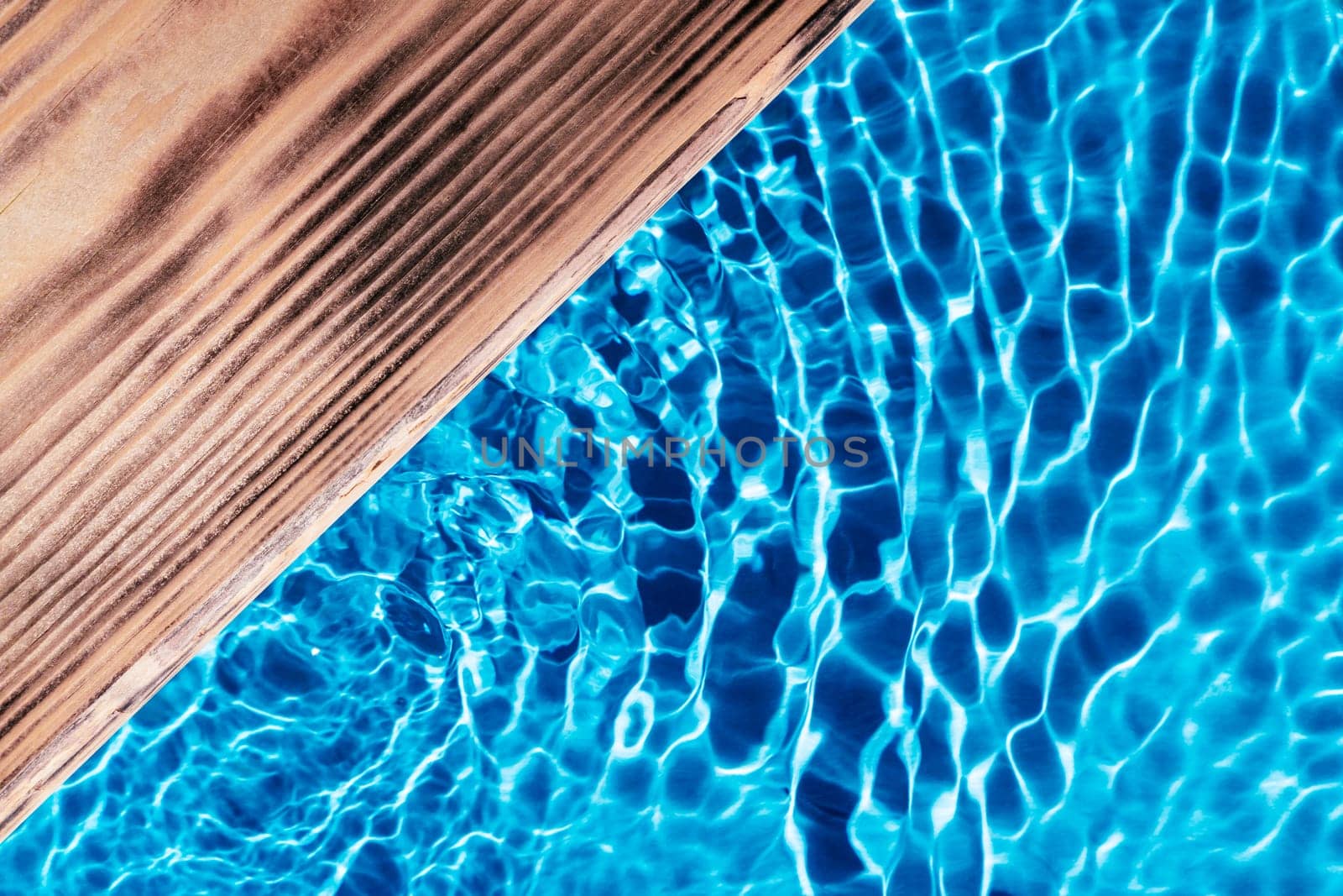 Wood platform table board in blue transparent reflect wave water surface ocean. Flat lay. Swimming pool. Healthy relaxation in sunny summer. Vacation spa coast sea, natural concept. Place for text