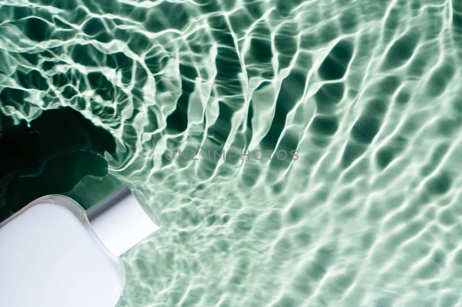 White square perfume bottle on green blue transparent reflect rippled wave water surface ocean. Fashion dermatology skin care. Right copy space. Place for text. Top view
