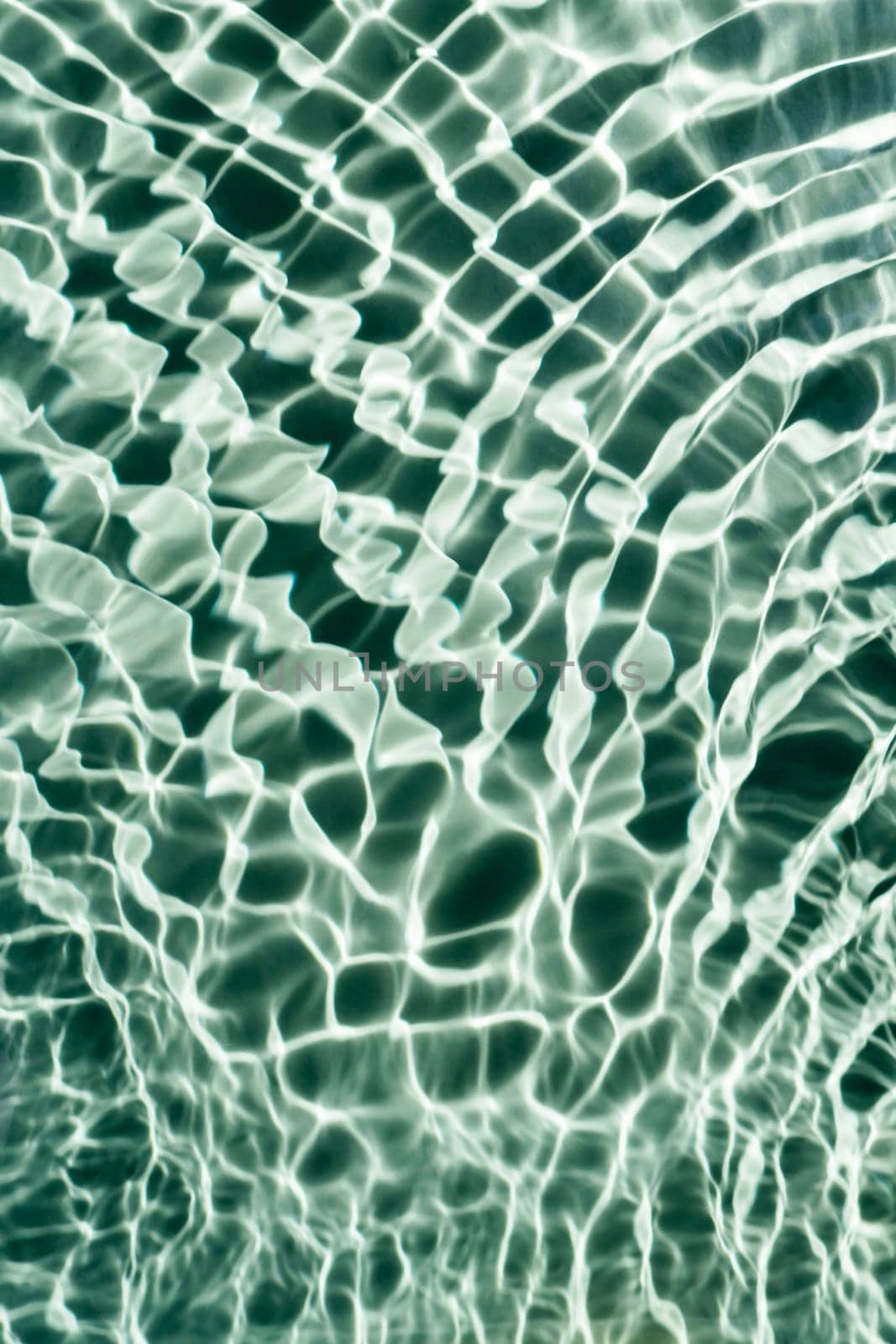 Rippled transparent fresh blue green water gel surface in swimming pool with flecks, waves, shade. Healthy relaxation in sunny summer. Vacation spa coast sea, natural concept. Vertical. Place for text