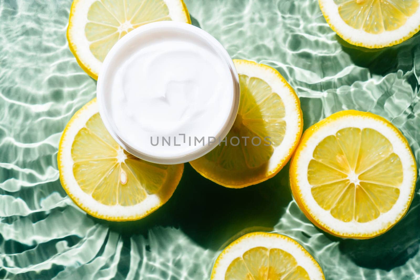 Facial jar cream milky beauty product with fruit citrus lemon slices in water splashing fresh transparent, flecks. Flat lay, top view. Summer beach tropical. Skin care in summer