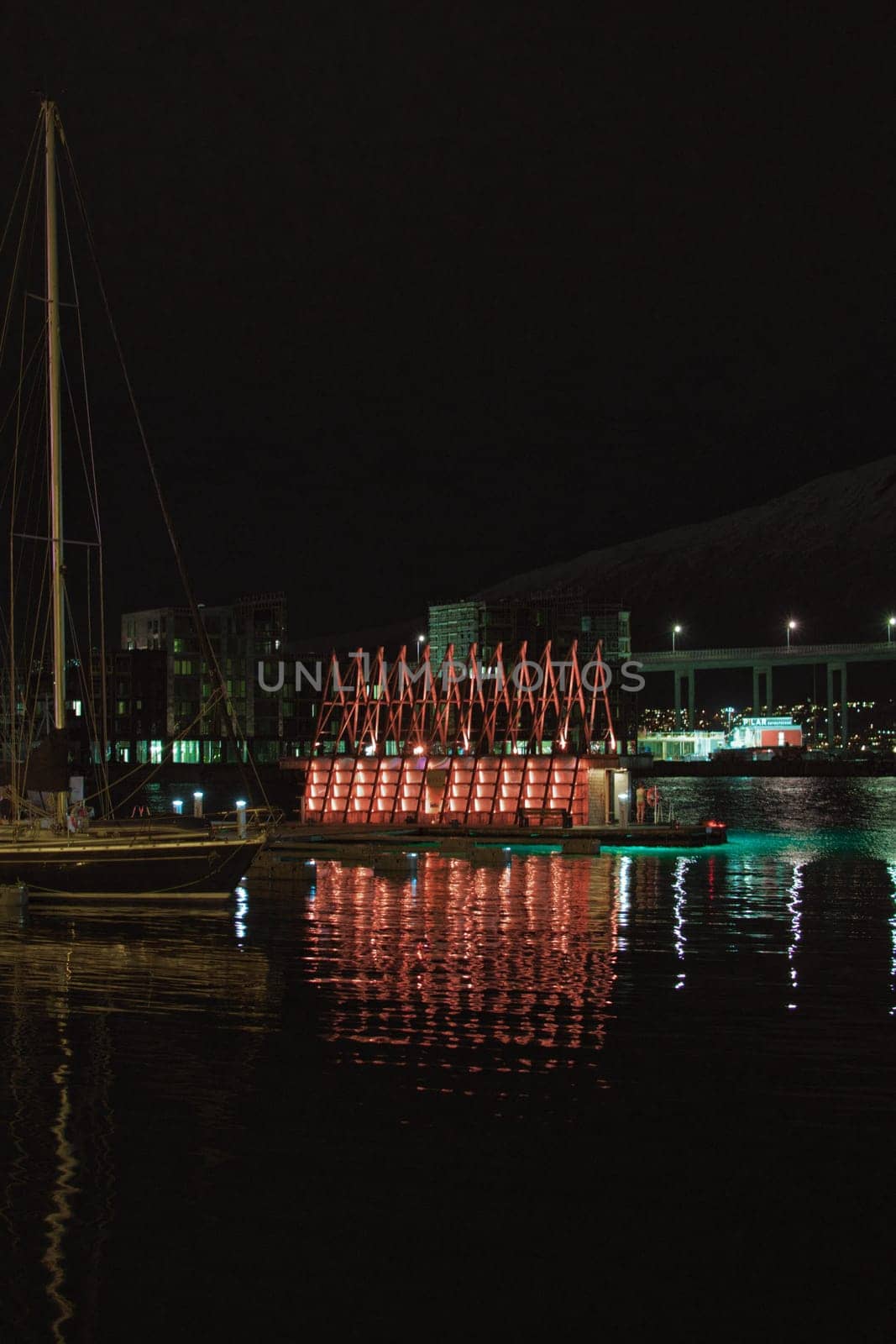 Vertical shot of the Sauna house in Tromso harbor at night. Norway