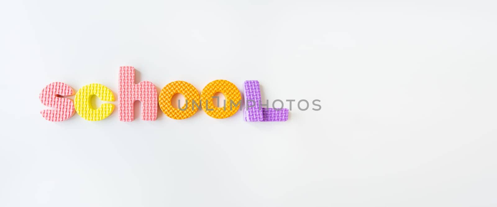 Banner with multi-colored letters. Letters for the study of children in kindergarten or school, fluted letters. School inscription