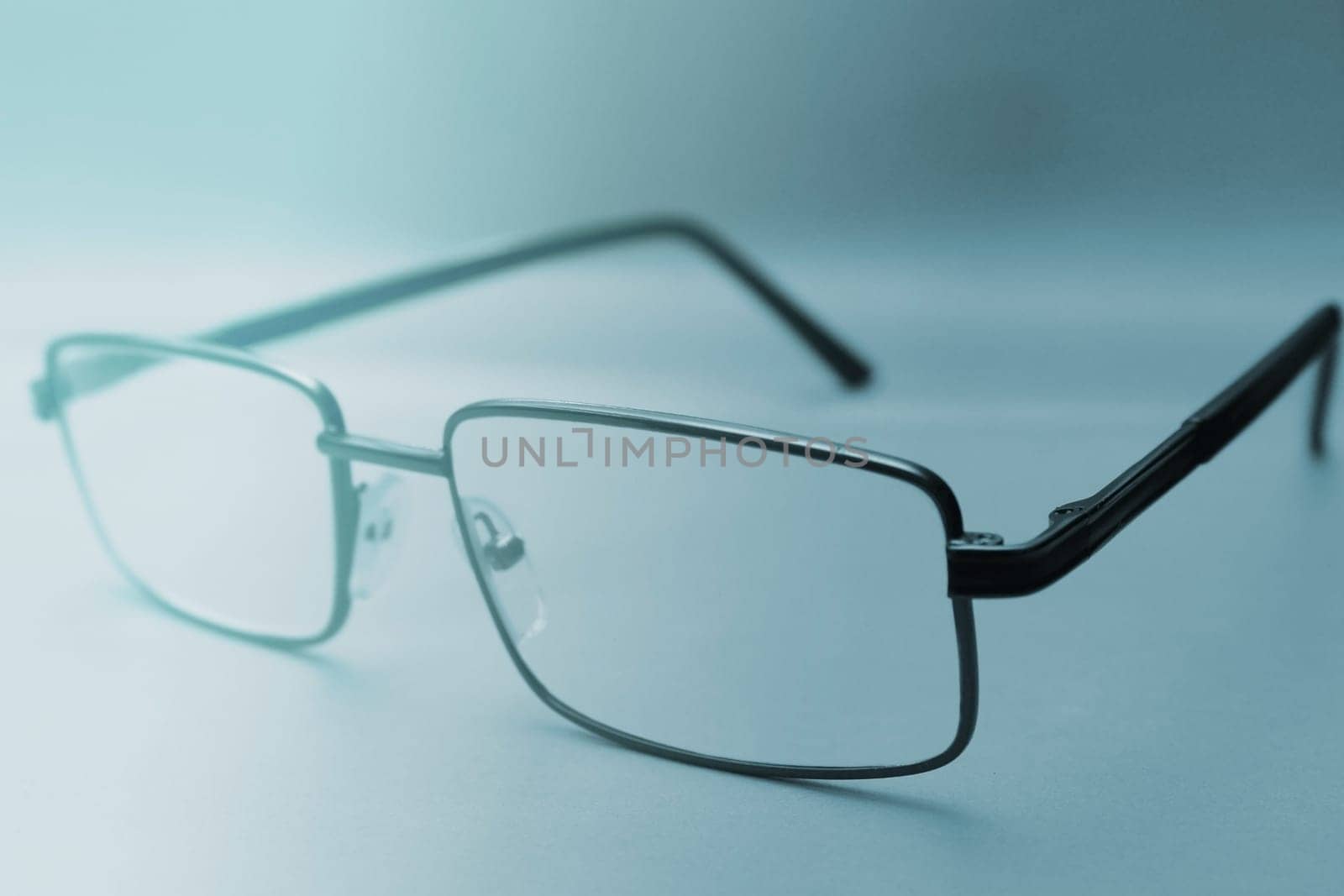 Glasses in a black frame on a blue background with copy space. World Day of Sight. Blurred background
