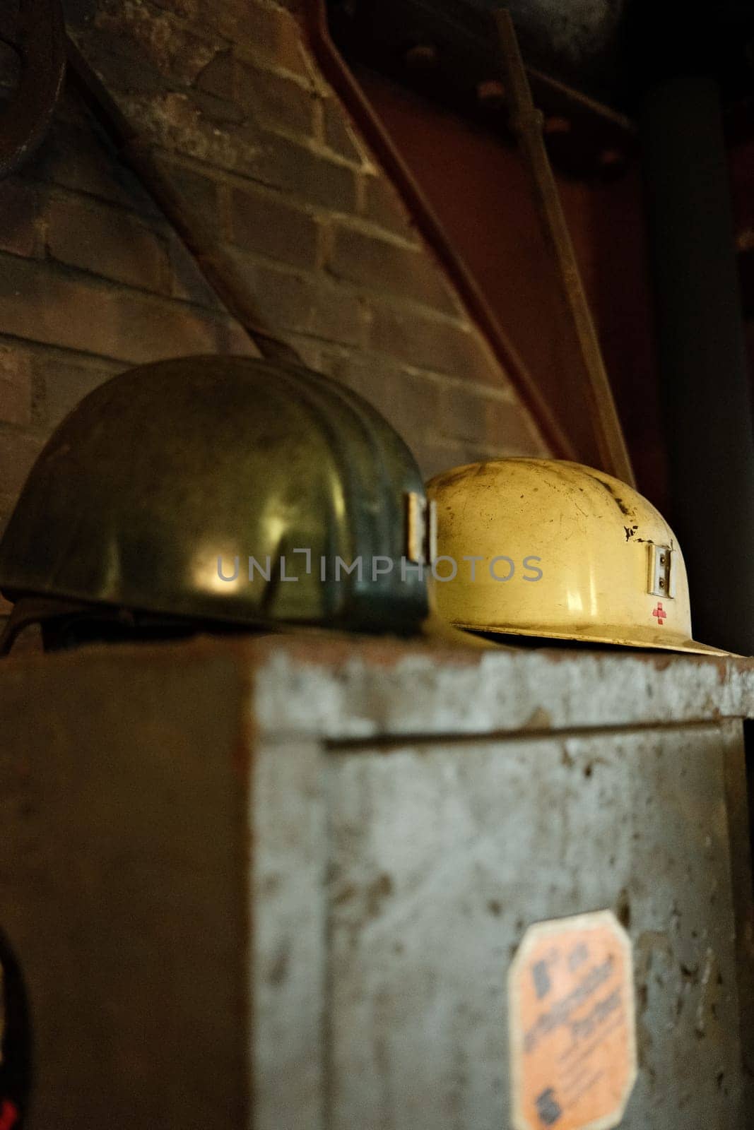 Closeup vertical shot of the miner's helmets on an old locker in a mine in the Ruhr area, Germany