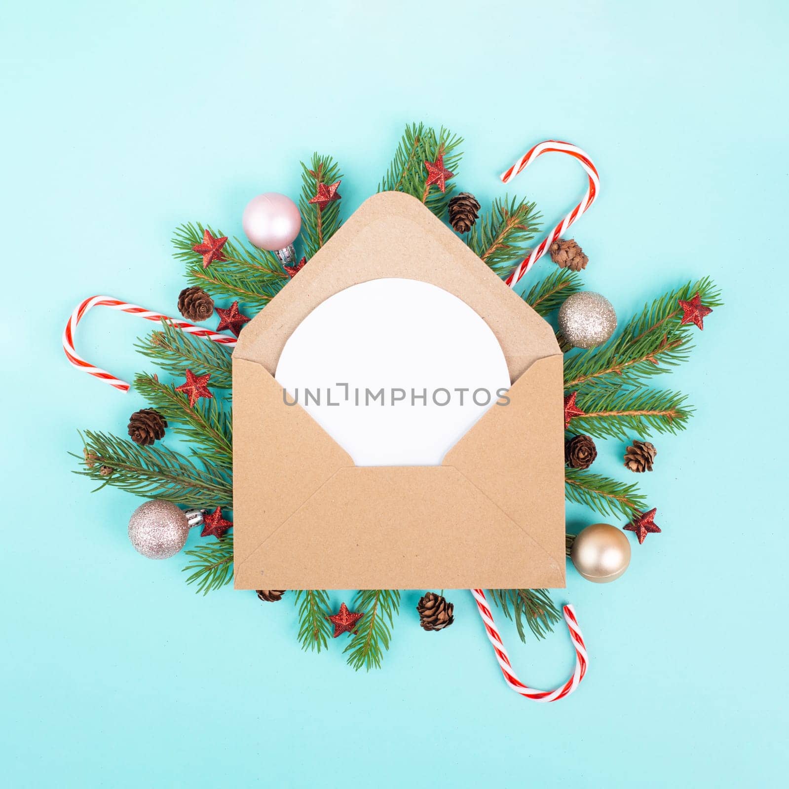 Christmas holiday background, enveloep with fir branches, baubles, candy cane and cones, winter season greeting card